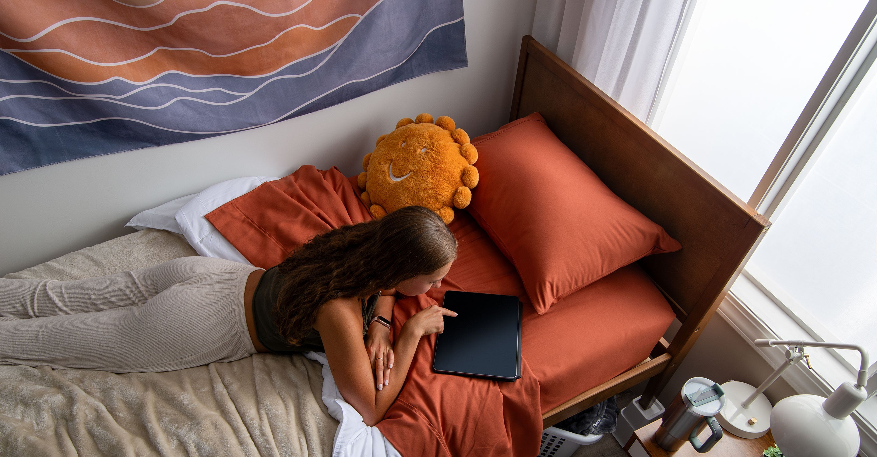 College student lying on a bed