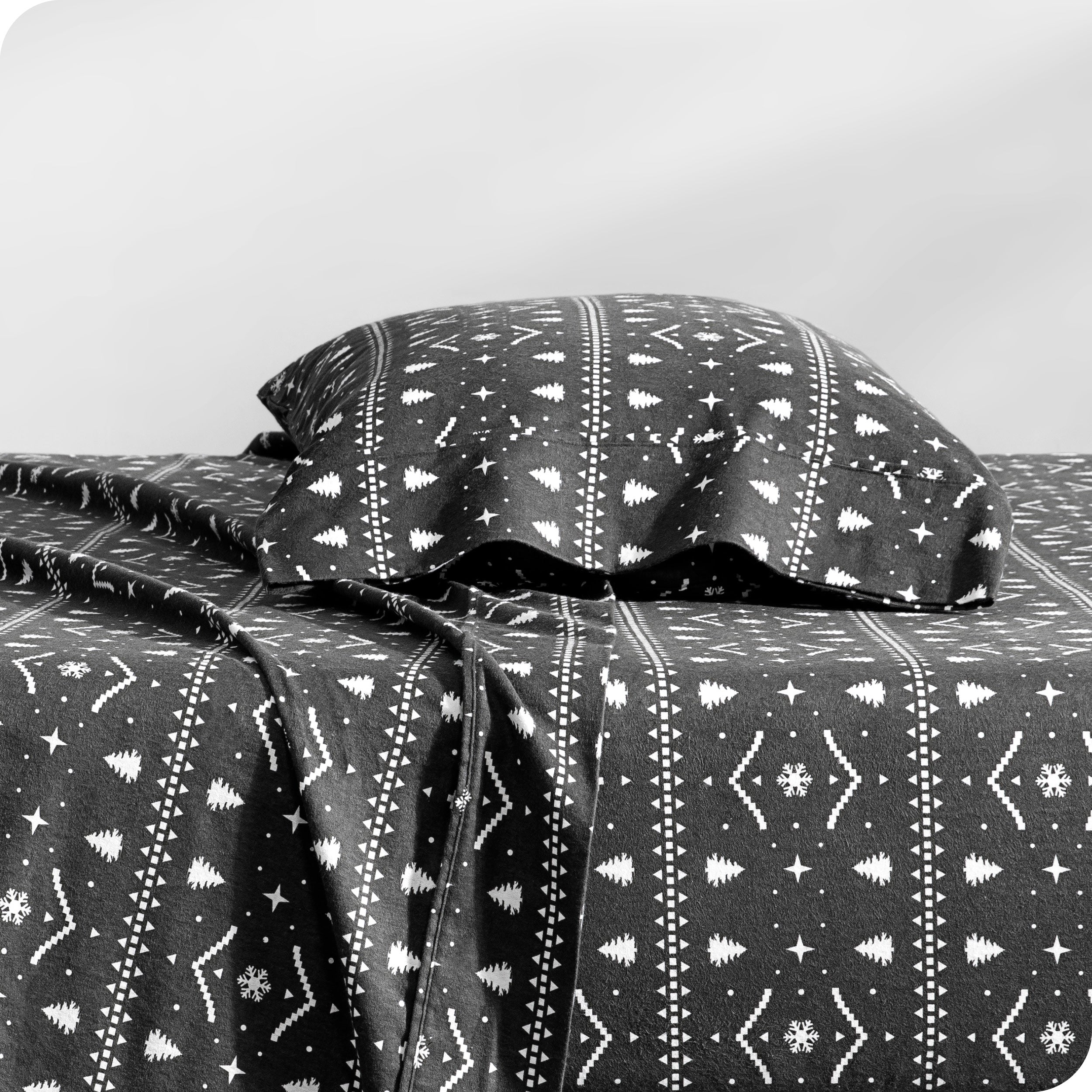 A flannel pillowcase on a pillow set on a bed with matching sheets
