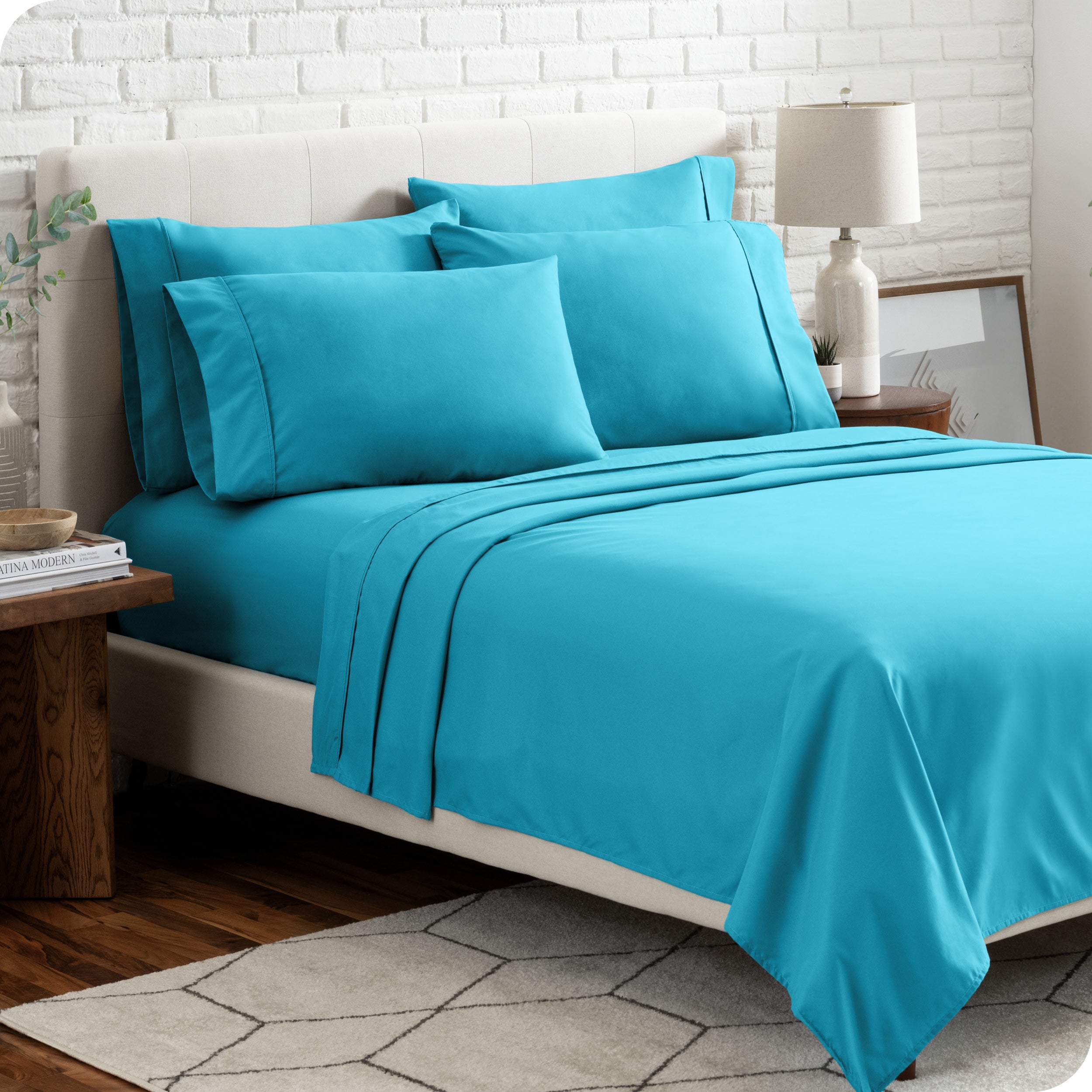 A bedroom setting with a bed made with the microfiber bed sheets and four pillows.
