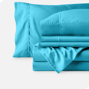 Microfiber sheets neatly folded with corner draped over, two folded pillowcases and two display pillows.
