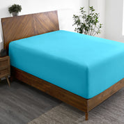 A wide corner view of a modern bed made with a microfiber fitted sheet on the mattress.