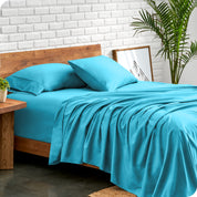 Microfiber sheets and matching pillowcases on a bed next to a large plant