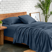 Microfiber sheets and matching pillowcases on a bed next to a large plant