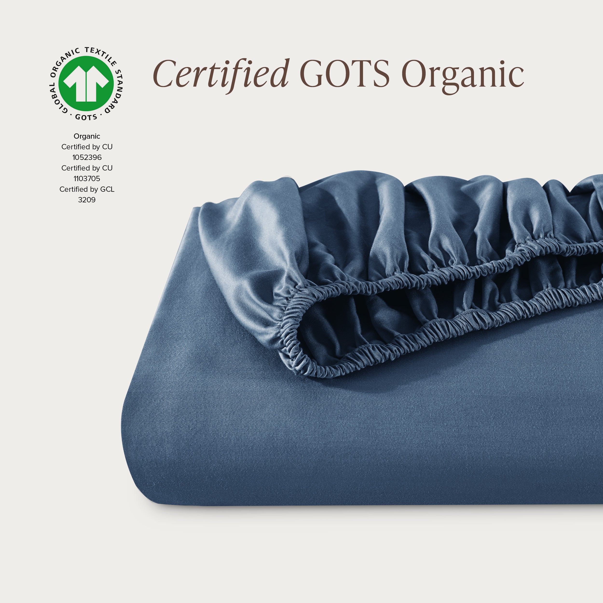 A single fitted sheet folded neatly showing part of the elastic. The fitted sheet is Certified GOTS Organic.
