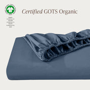 A single fitted sheet folded neatly showing part of the elastic. The fitted sheet is Certified GOTS Organic.