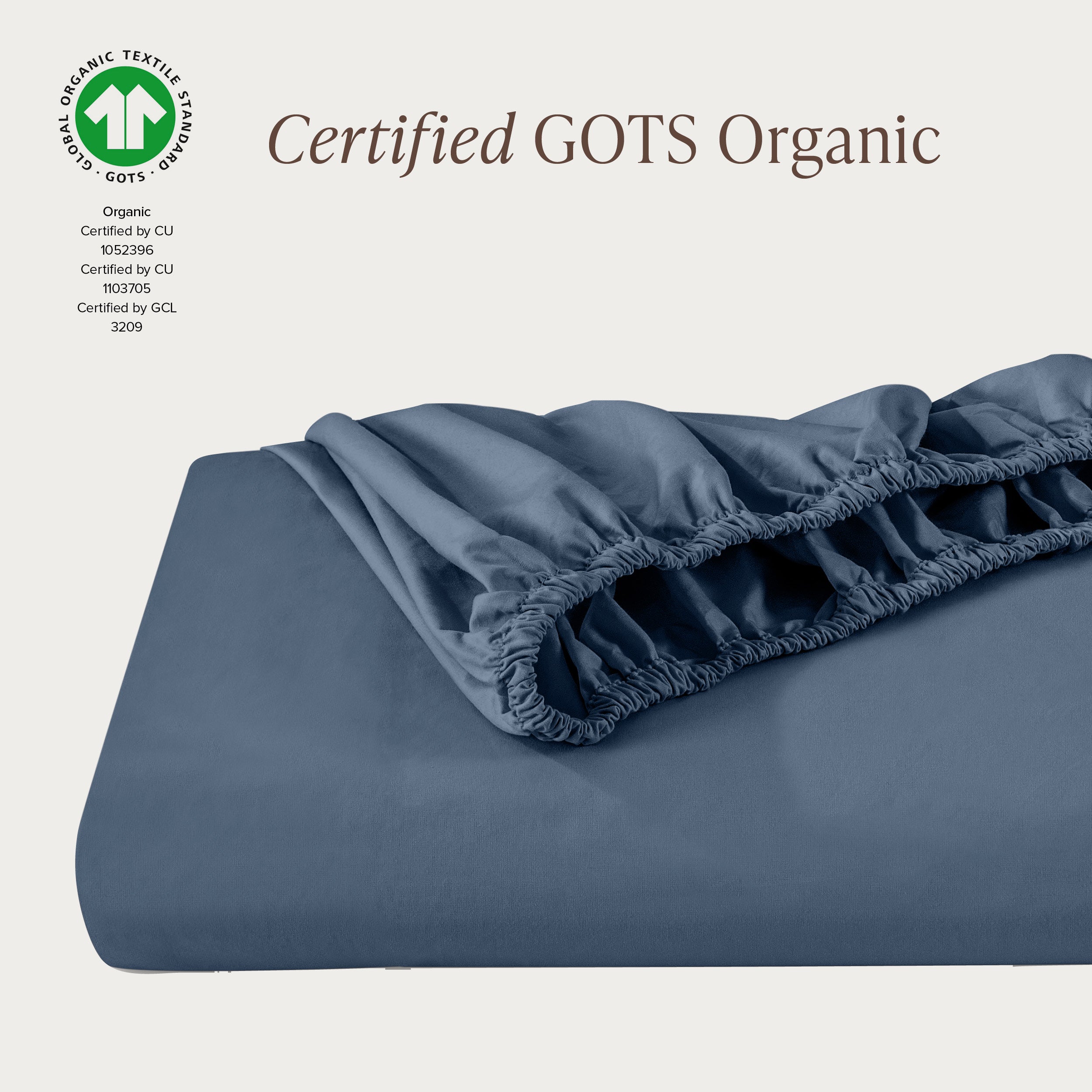 A single fitted sheet folded neatly showing part of the elastic. The fitted sheet is Certified GOTS Organic.