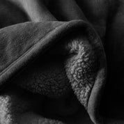 Close up of sherpa blanket showing texture of velvety soft side and sherpa backing