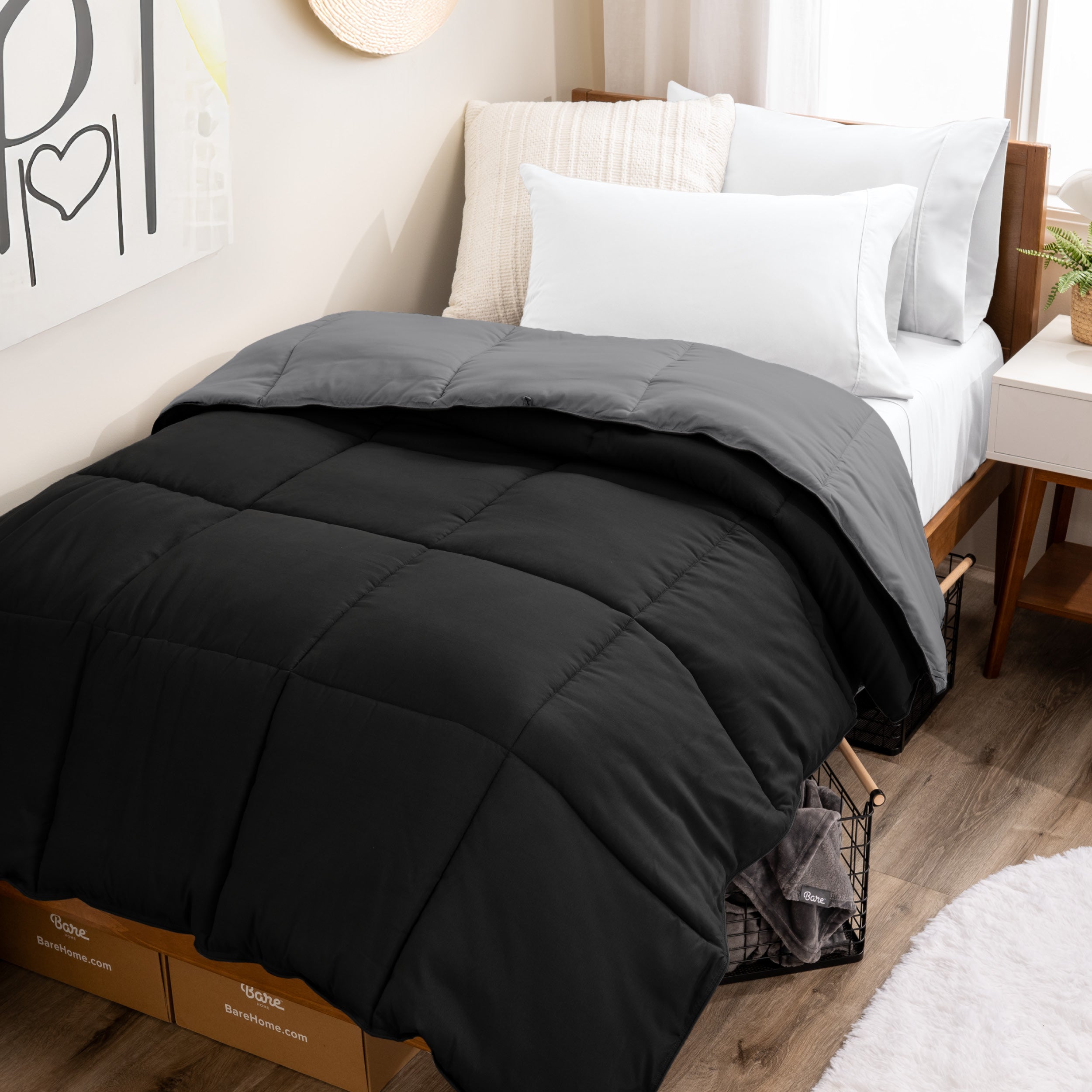 Wooden bed frame with a reversible comforter on the bed. The comforter is folded back over showing the two different colors.