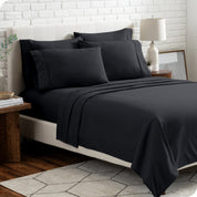 A bedroom setting with a bed made with the microfiber bed sheets and four pillows.