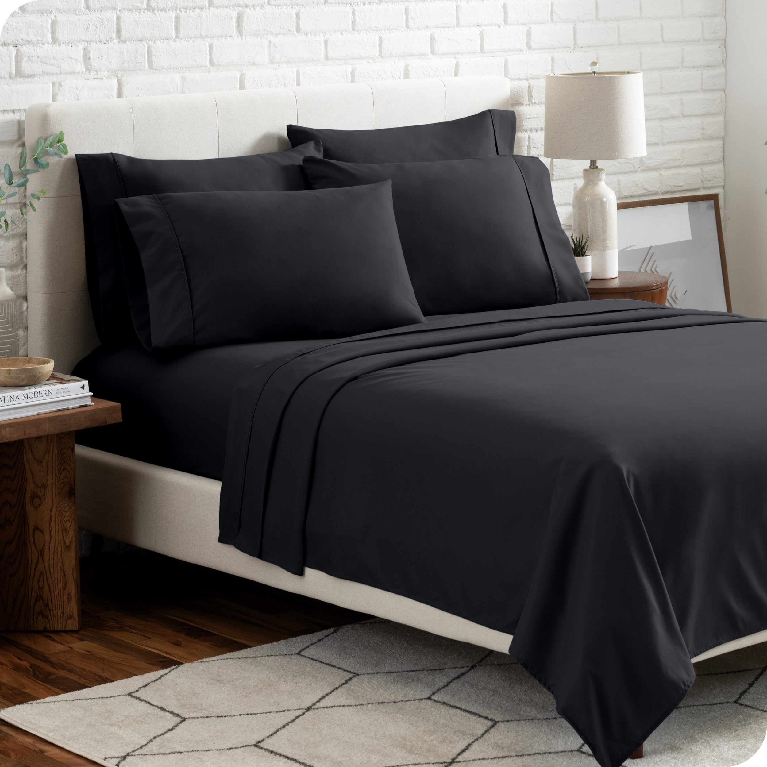 A bedroom setting with a bed made with the microfiber bed sheets and four pillows.