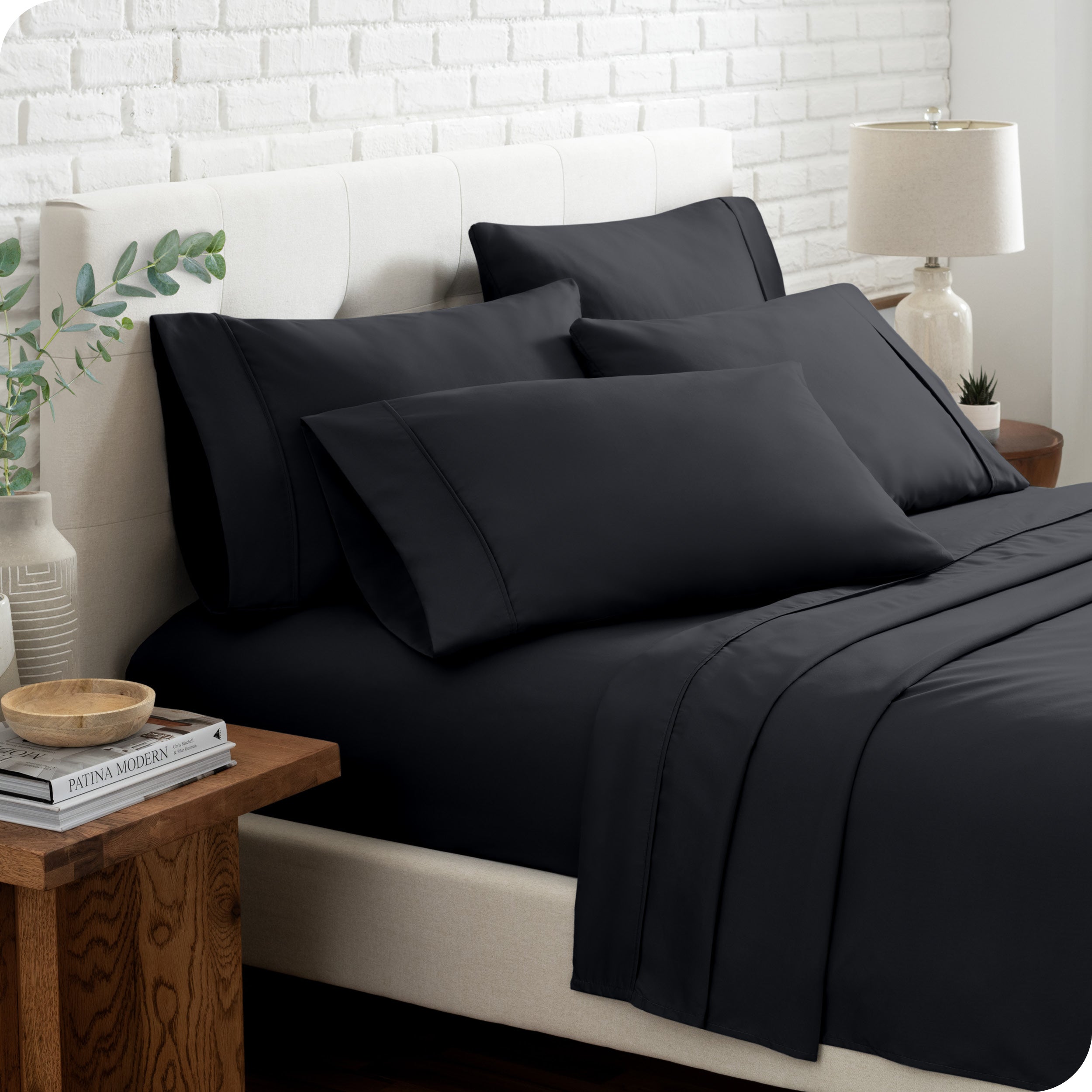 Close up of the microfiber bed sheets on a bed with four pillows.