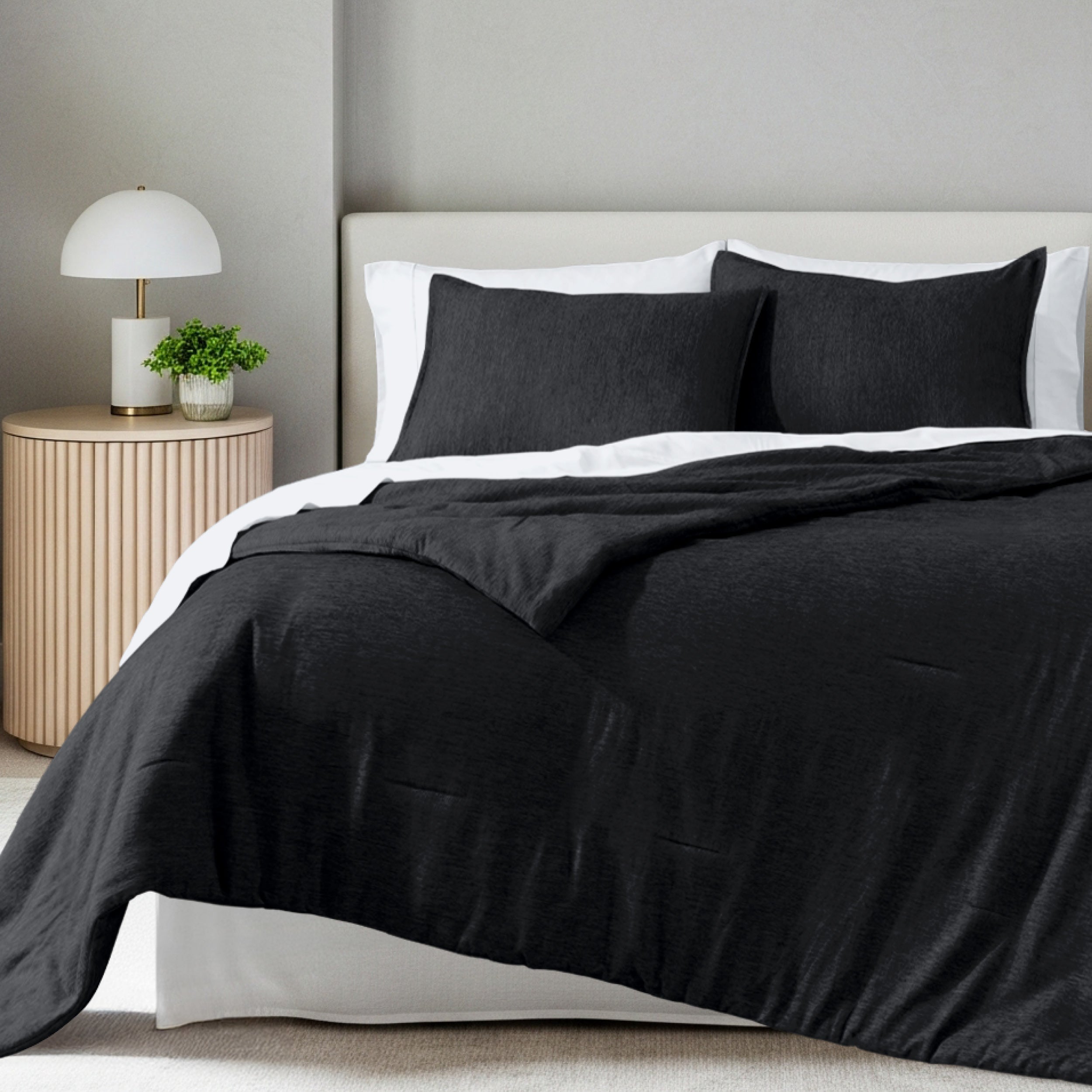 A comforter set on a bed in a bright modern room
