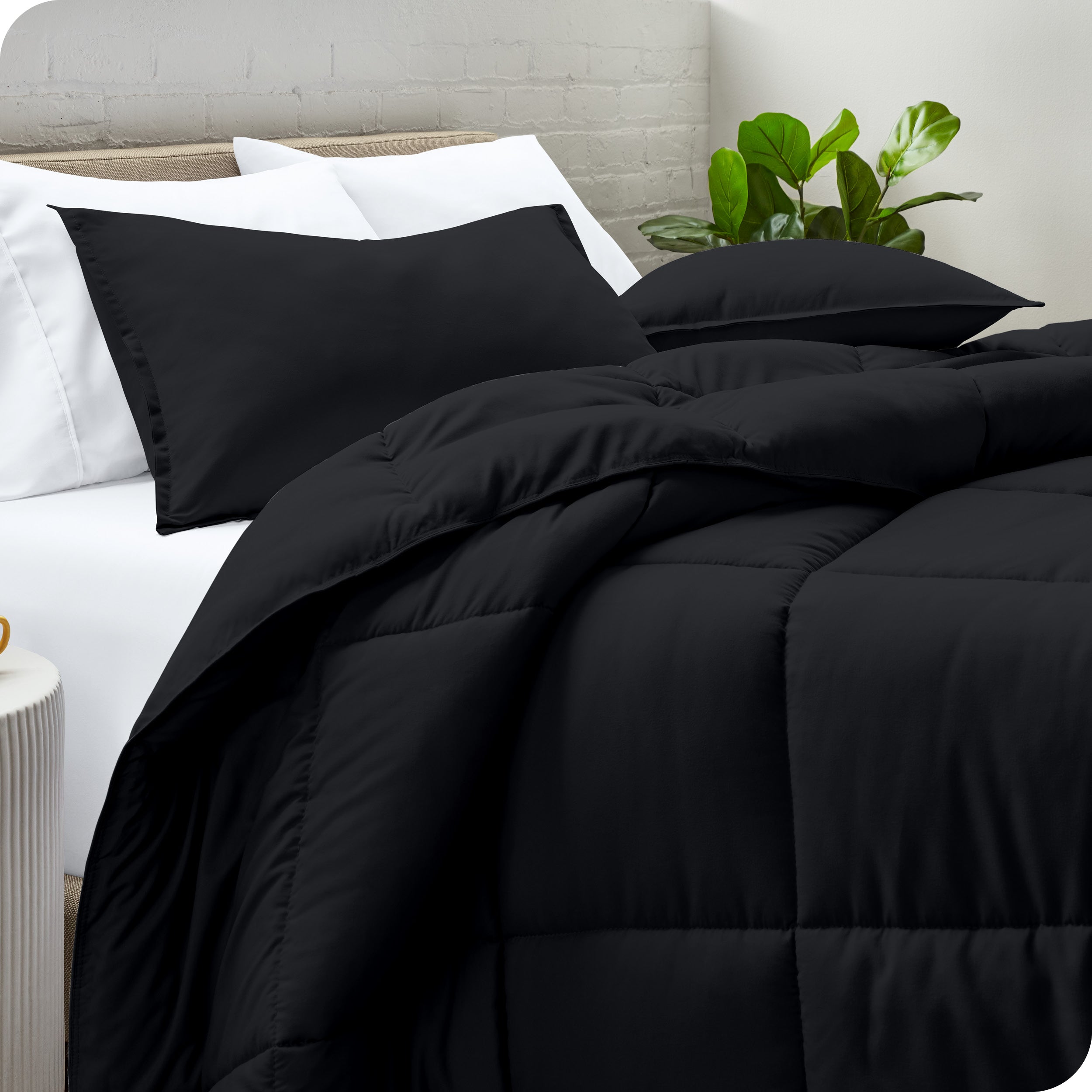 A side view of a modern bed with a comforter set and pillows on the bed
