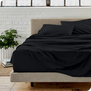 Microfiber sheets on a bed with a brick wall behind it