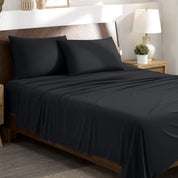 Stretch sheets on a bed with a wooden headboard in a bedroom setting.