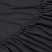 Close-up of a fitted sheet with elastic edge on a bed.
