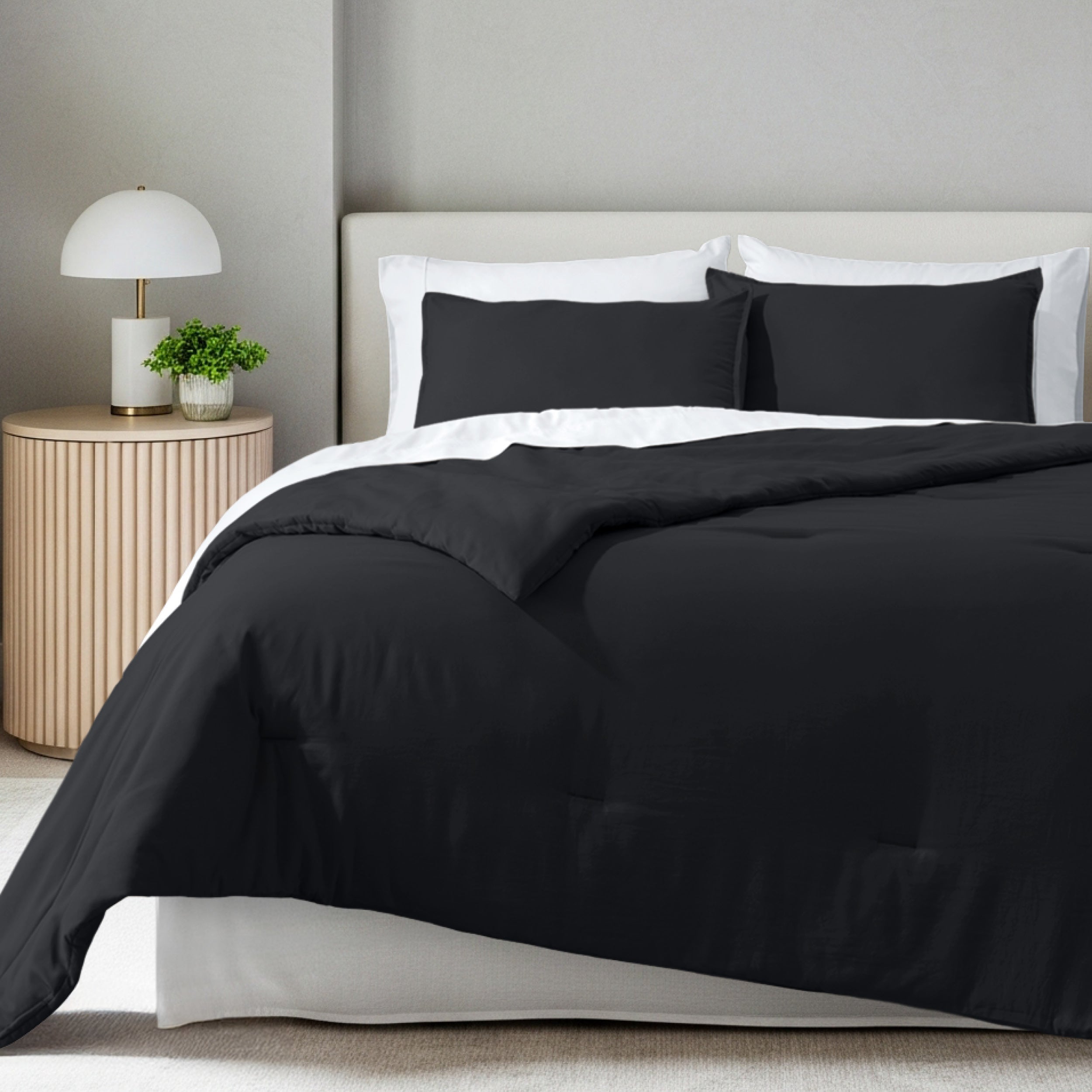 A comforter set on a bed in a bright modern room