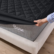 The corner of a mattress with a mattress pad putting on it