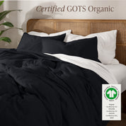 A bed made with an GOTs certified organic jersey duvet cover, pillow sham covered pillows and extra pillows
