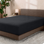 A sideview of a modern bed with a polar fleece fitted sheet on.