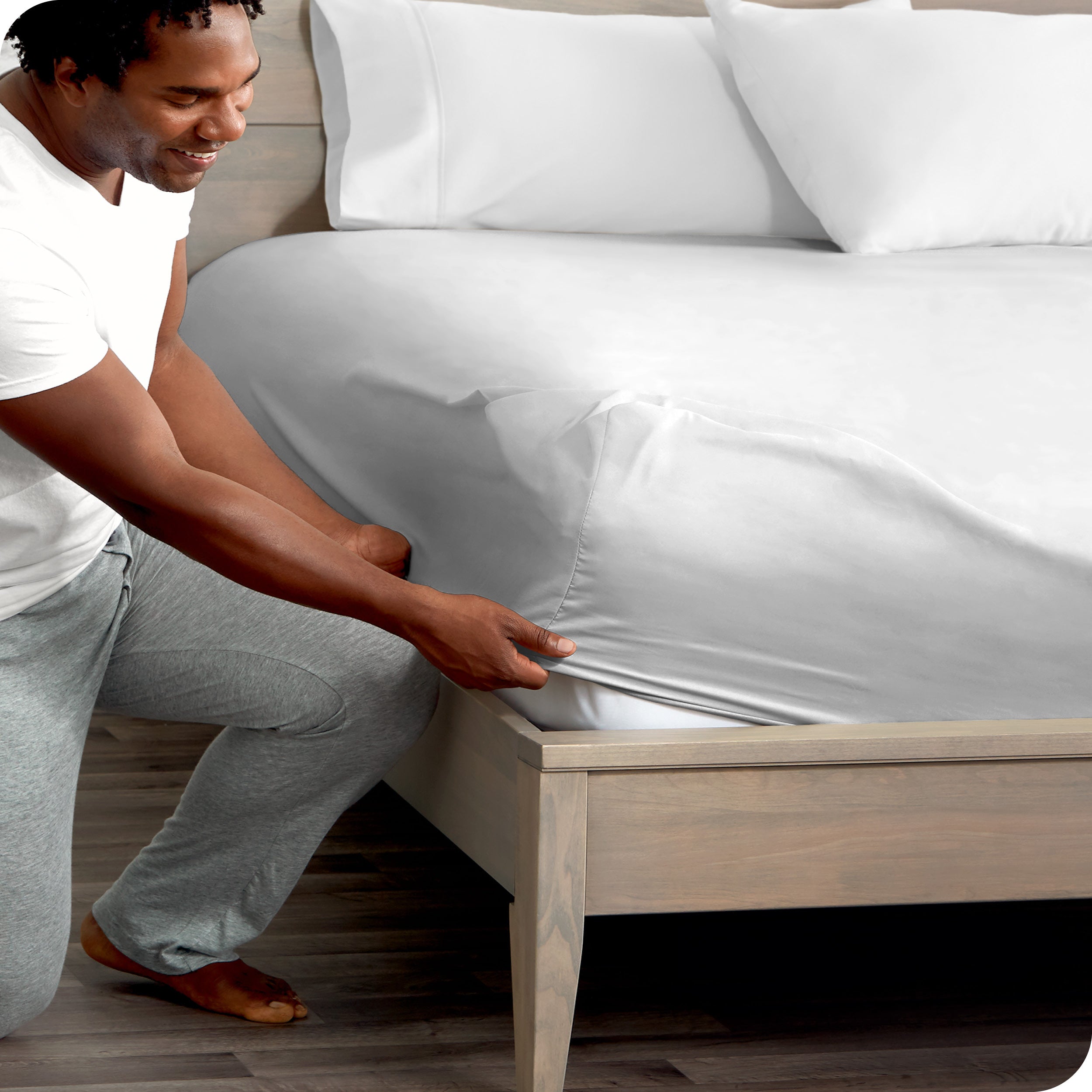 A modern bed with a fitted microfiber sheet on it