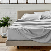 Microfiber sheets on a bed with a brick wall behind it