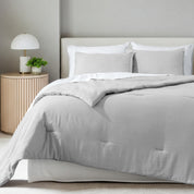 A comforter set on a bed in a bright modern room