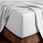 A corner of bed with fitted sheet to show the deep pocket feature and the texture.