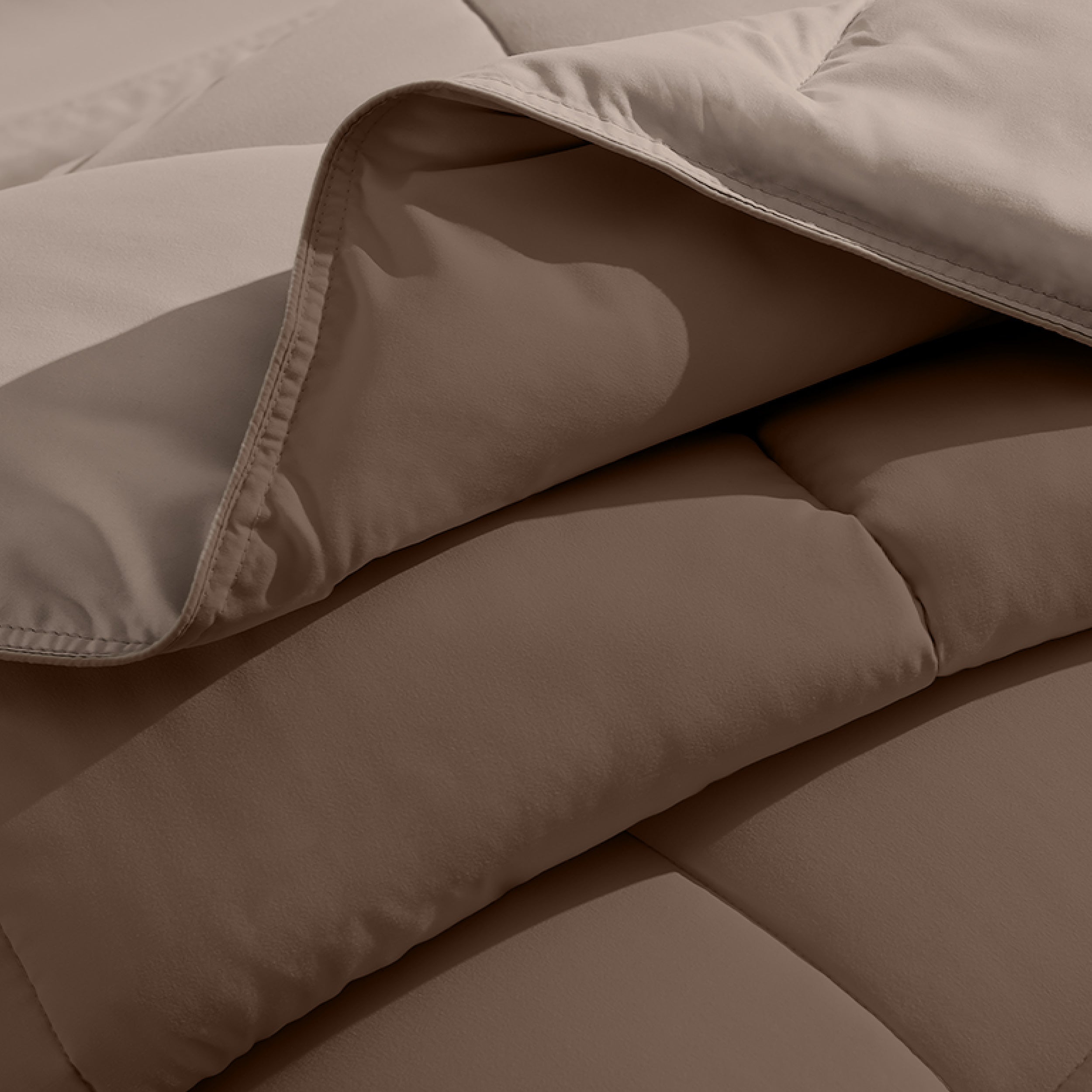 Close up of the reversible comforter showing the box stitching and the two colors