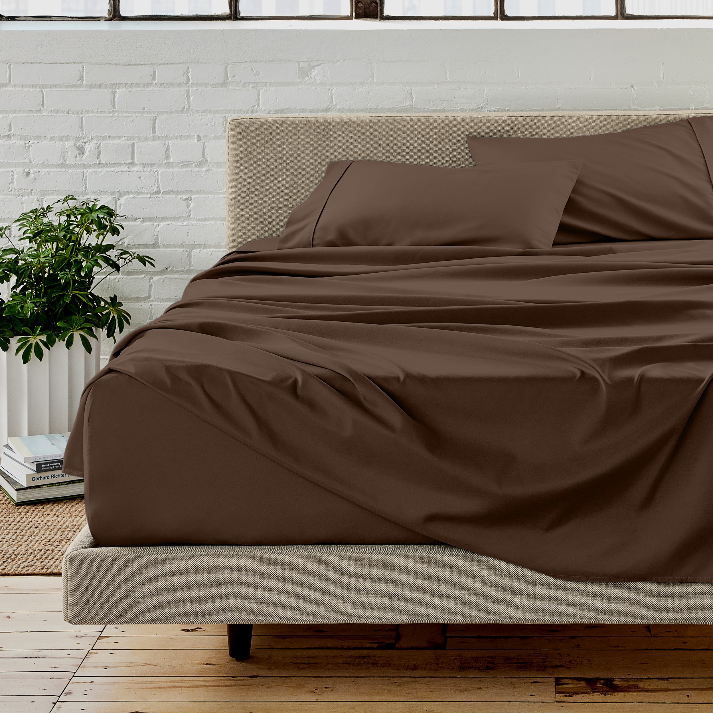 The sheet set with the matched same color pillowcases putting over the bed in a modern room.