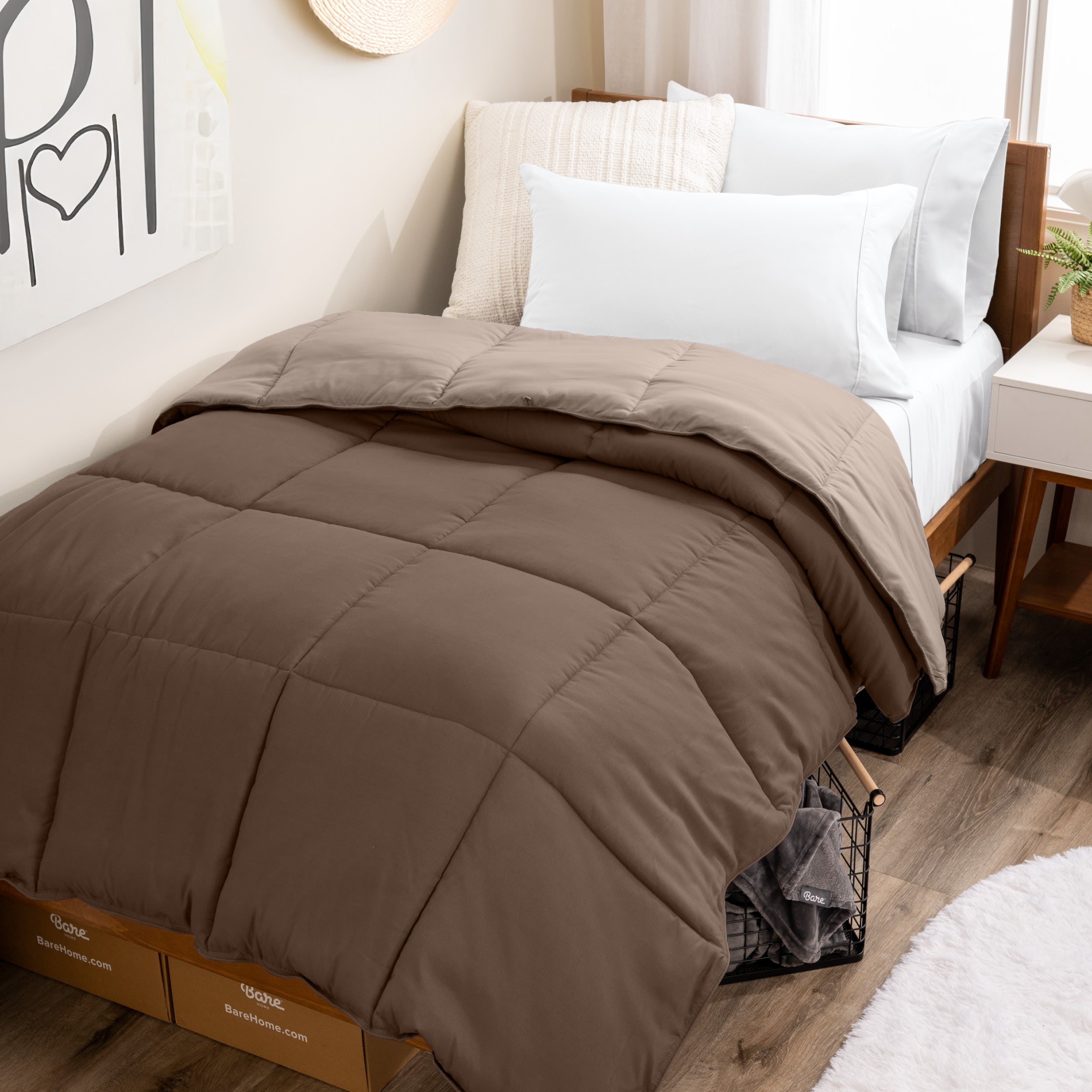 Wooden bed frame with a reversible comforter on the bed. The comforter is folded back over showing the two different colors.