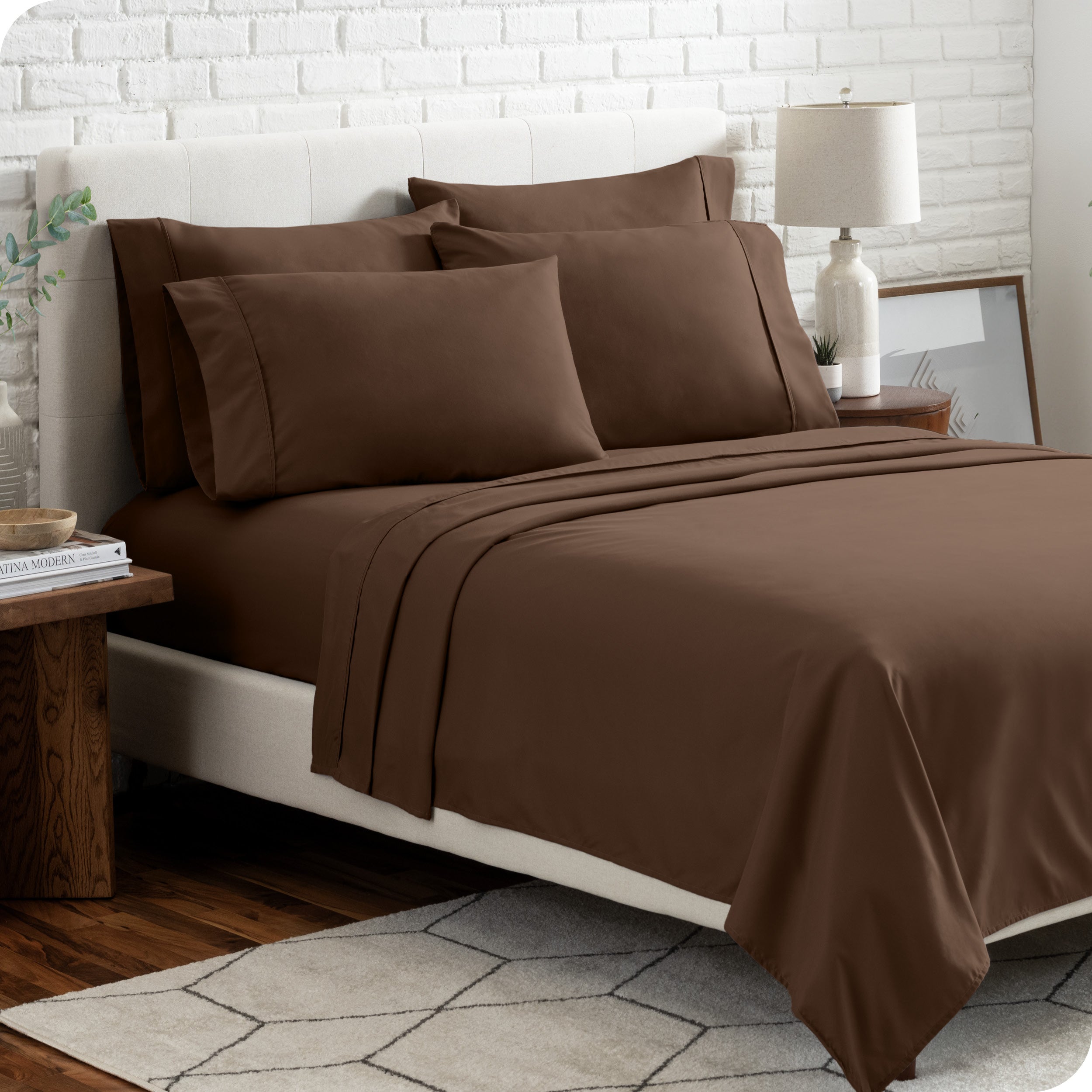 A bedroom setting with a bed made with the microfiber bed sheets and four pillows.