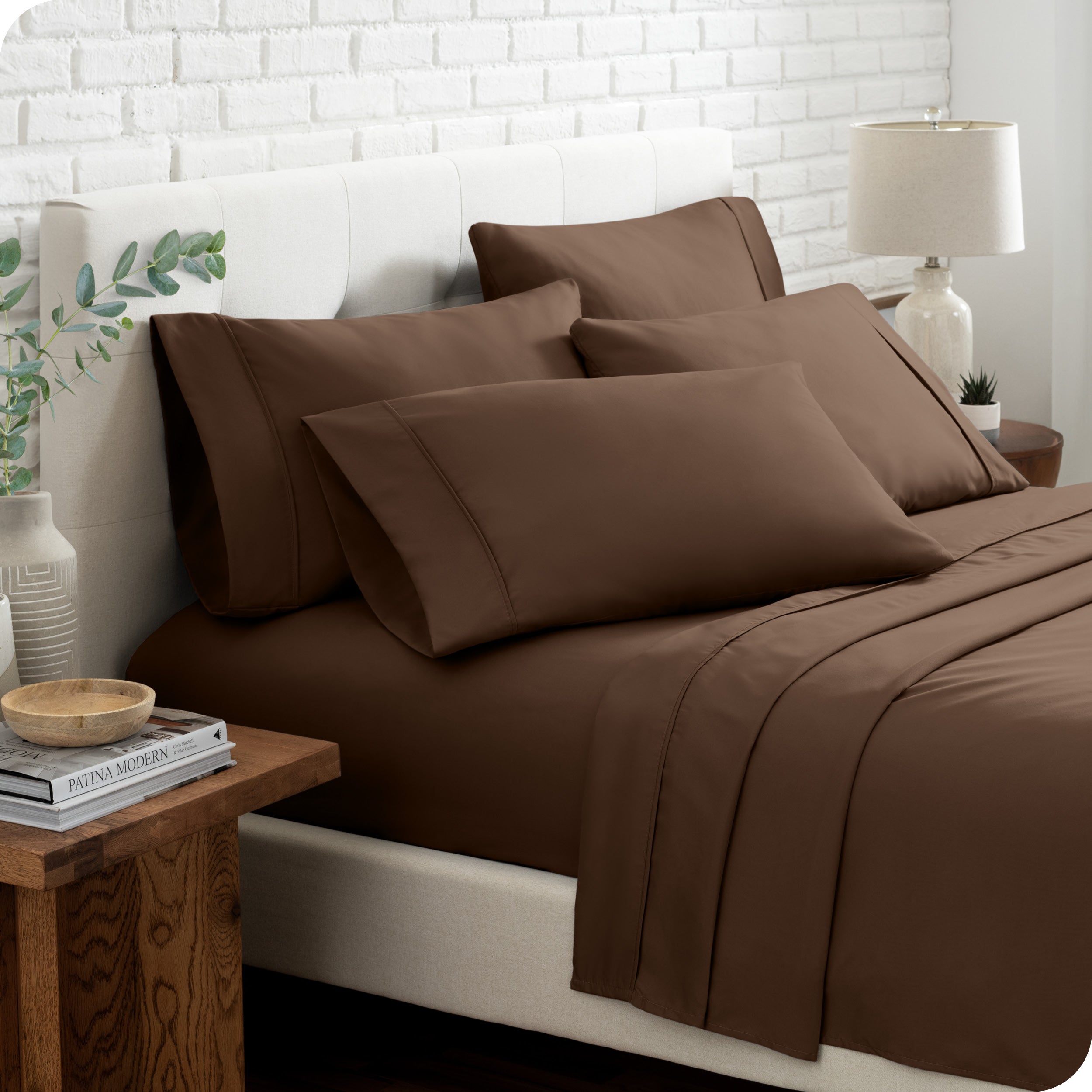 Close up of the microfiber bed sheets on a bed with four pillows.