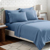 A bedroom setting with a bed made with the microfiber bed sheets and four pillows.