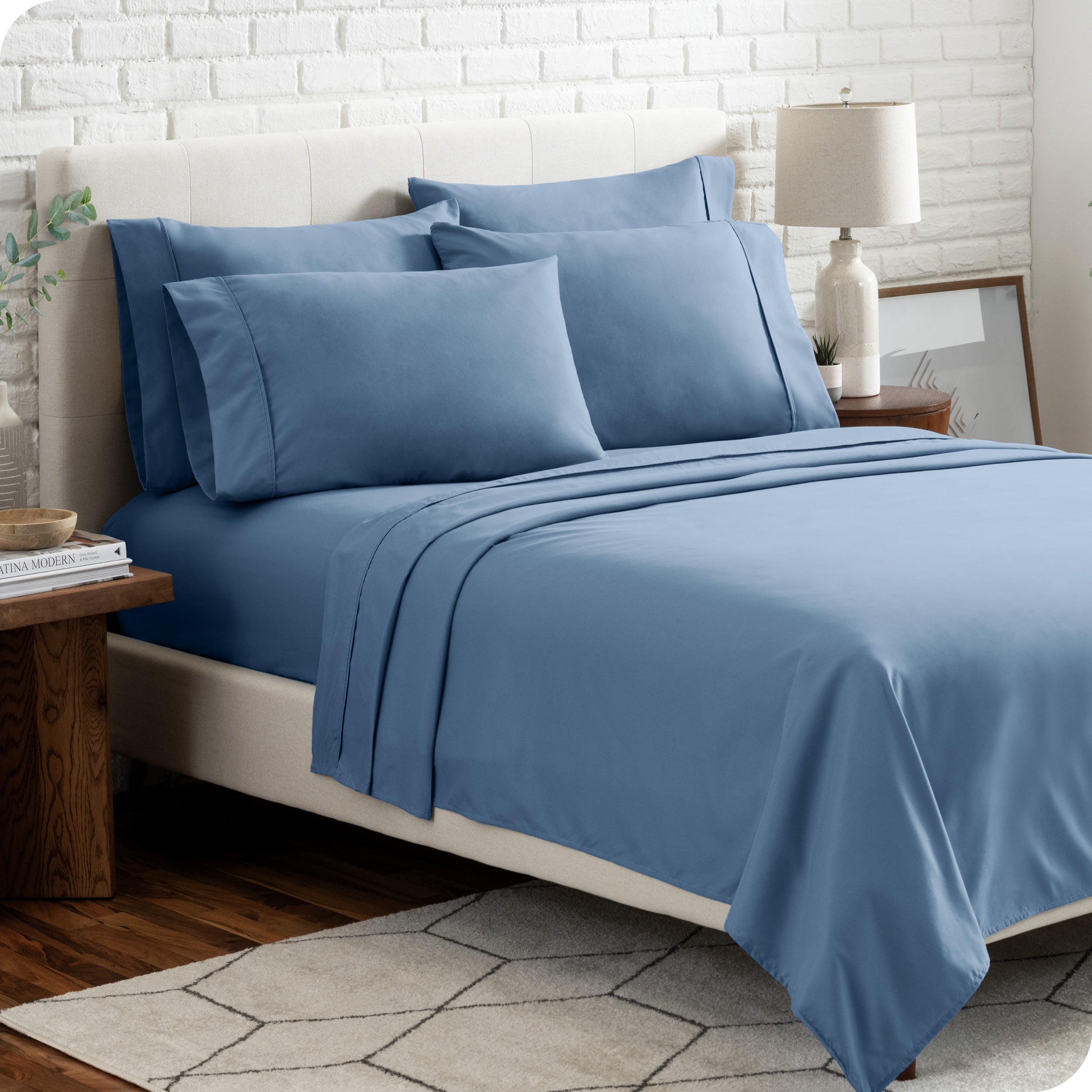 A bedroom setting with a bed made with the microfiber bed sheets and four pillows.