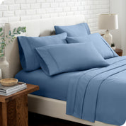 Close up of the microfiber bed sheets on a bed with four pillows.