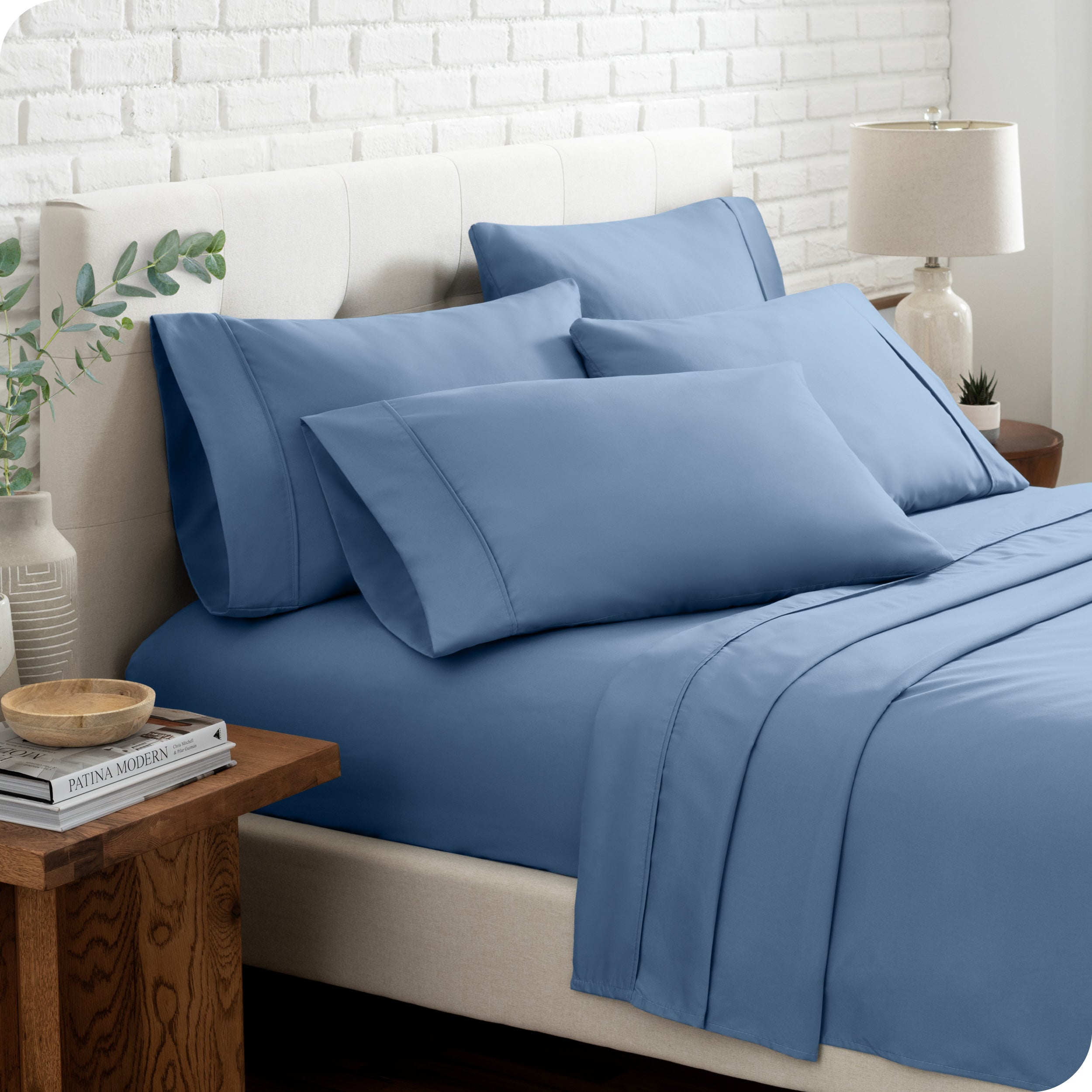 Close up of the microfiber bed sheets on a bed with four pillows.