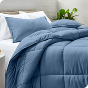 A side view of a modern bed with a comforter set and pillows on the bed