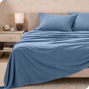 View of fleece sheets from the end of a bed with the top sheet draped over the side and end