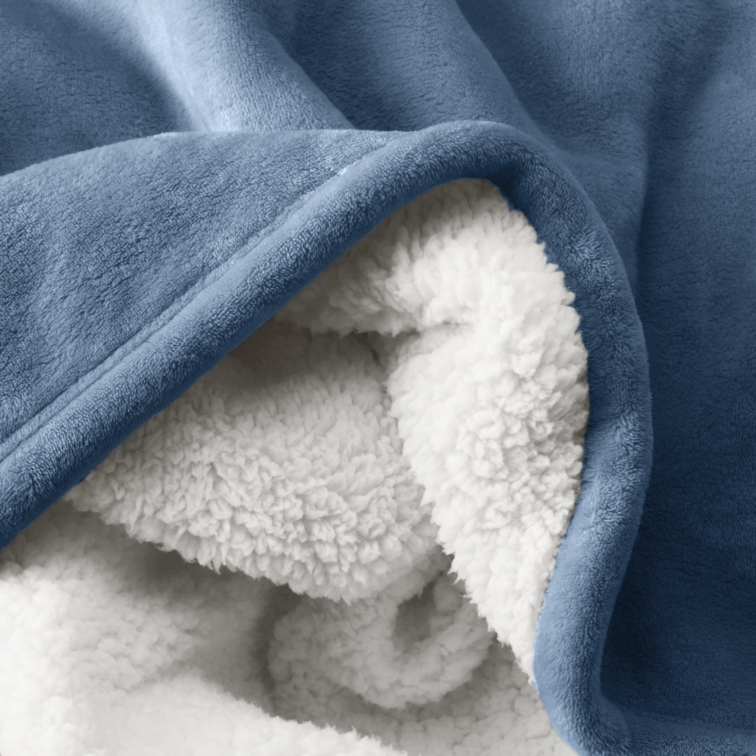 Close up of sherpa blanket showing texture of velvety soft side and sherpa backing