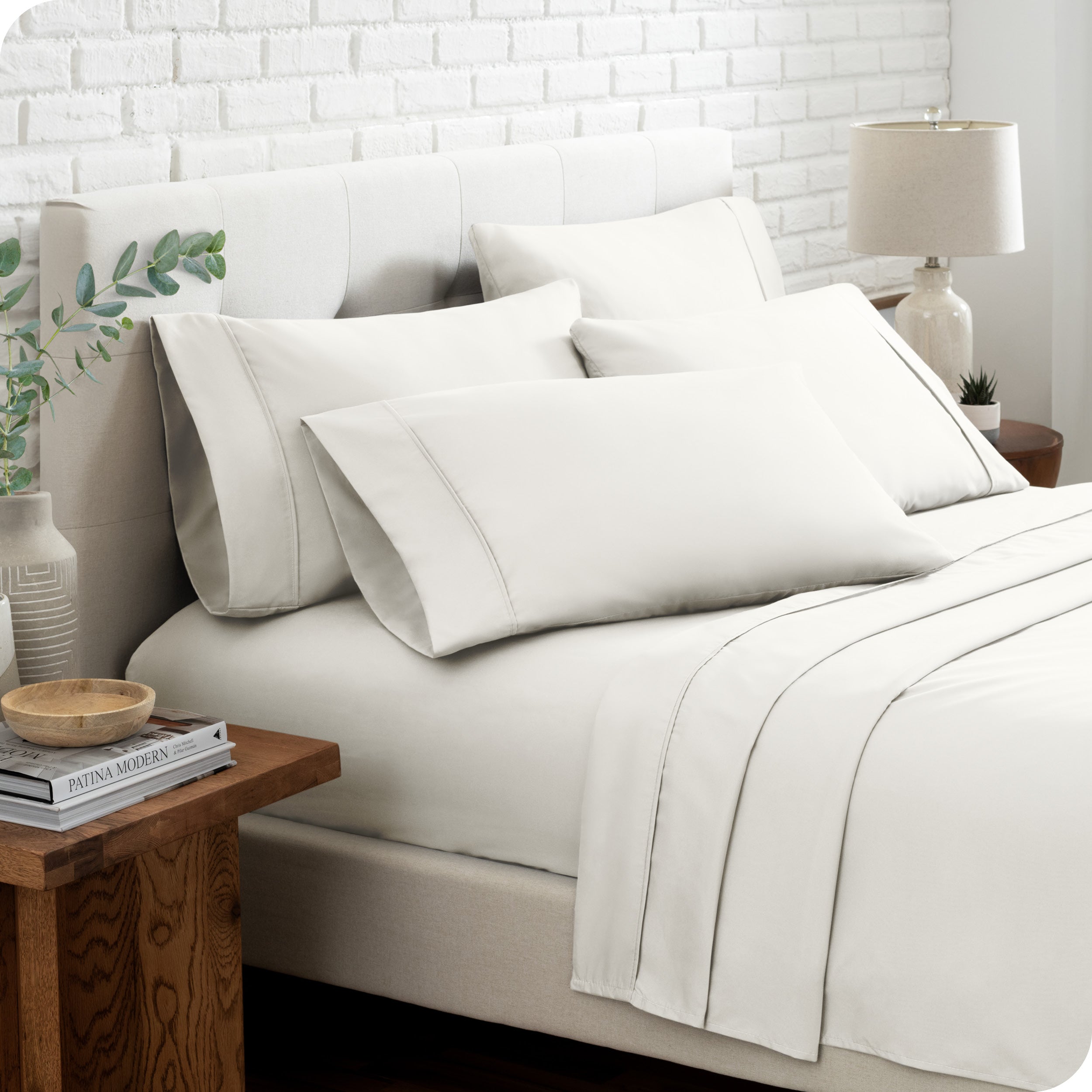 Close up of the microfiber bed sheets on a bed with four pillows.