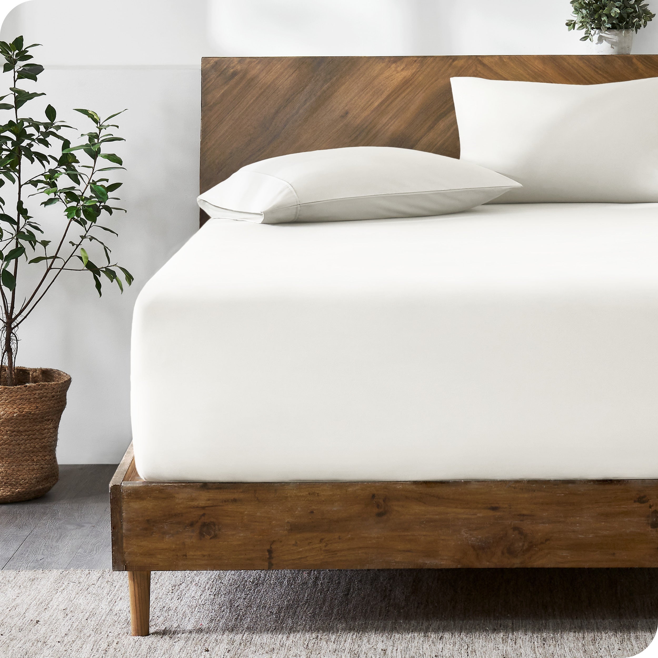 A modern bed with a fitted microfiber sheet made on the mattress.