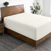 A wide corner view of a modern bed made with a microfiber fitted sheet on the mattress.