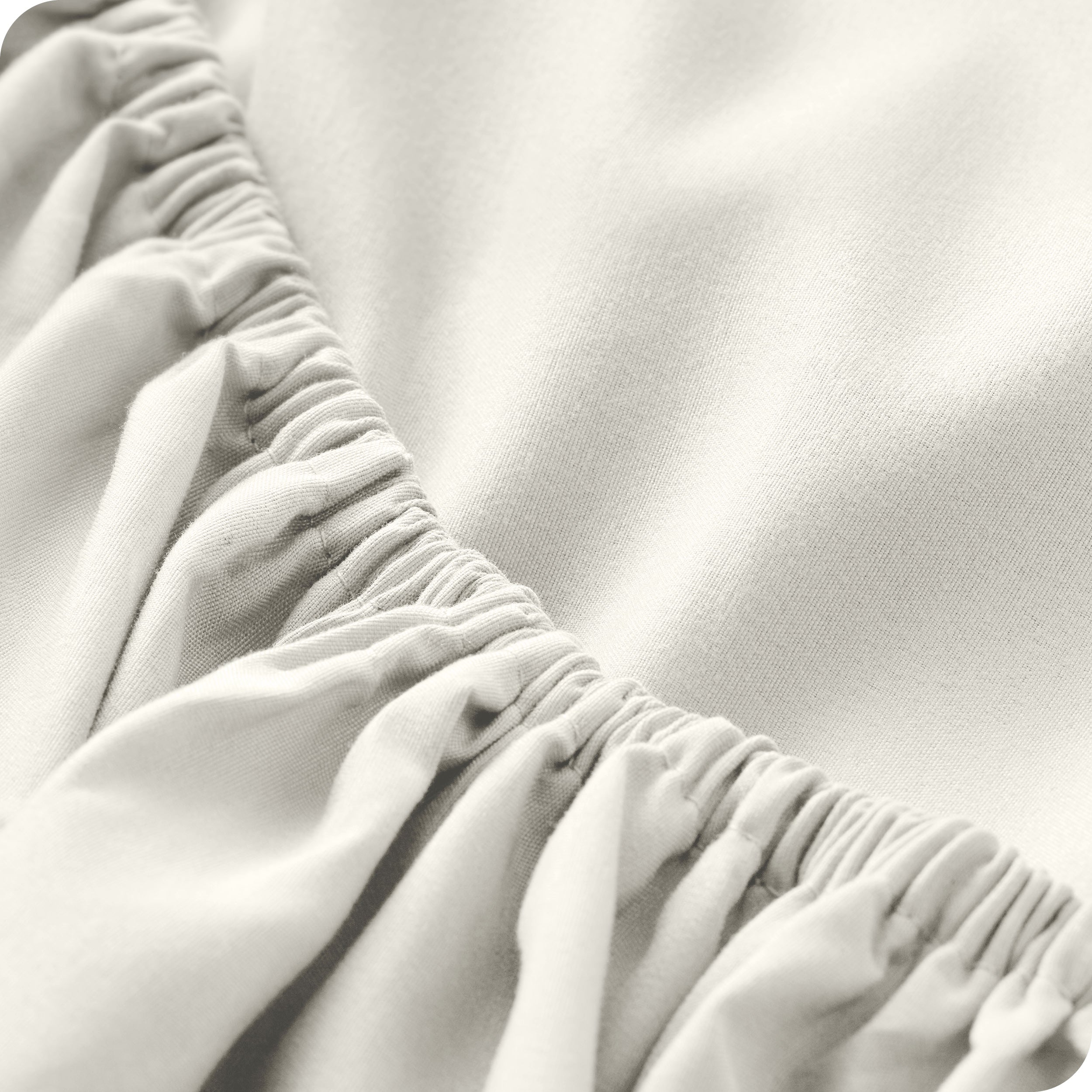 A modern bed with a fitted microfiber sheet on it