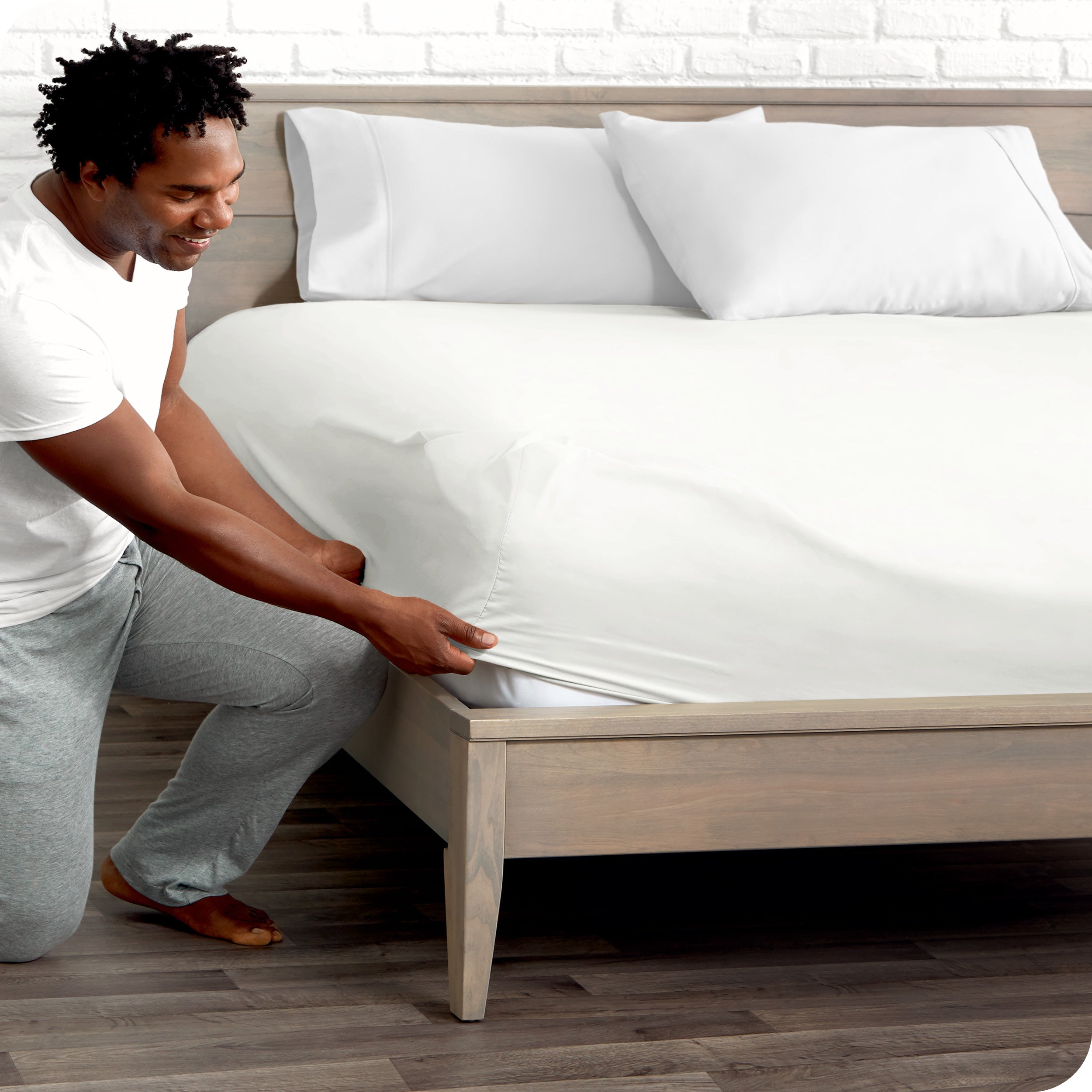 A man putting the microfiber fitted sheet on a mattress.