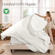 Woman putting bedding on a bed with GOTS Organic certification logo in the corner.