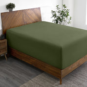 A wide corner view of a modern bed made with a microfiber fitted sheet on the mattress.