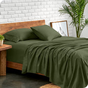 Microfiber sheets and matching pillowcases on a bed next to a large plant
