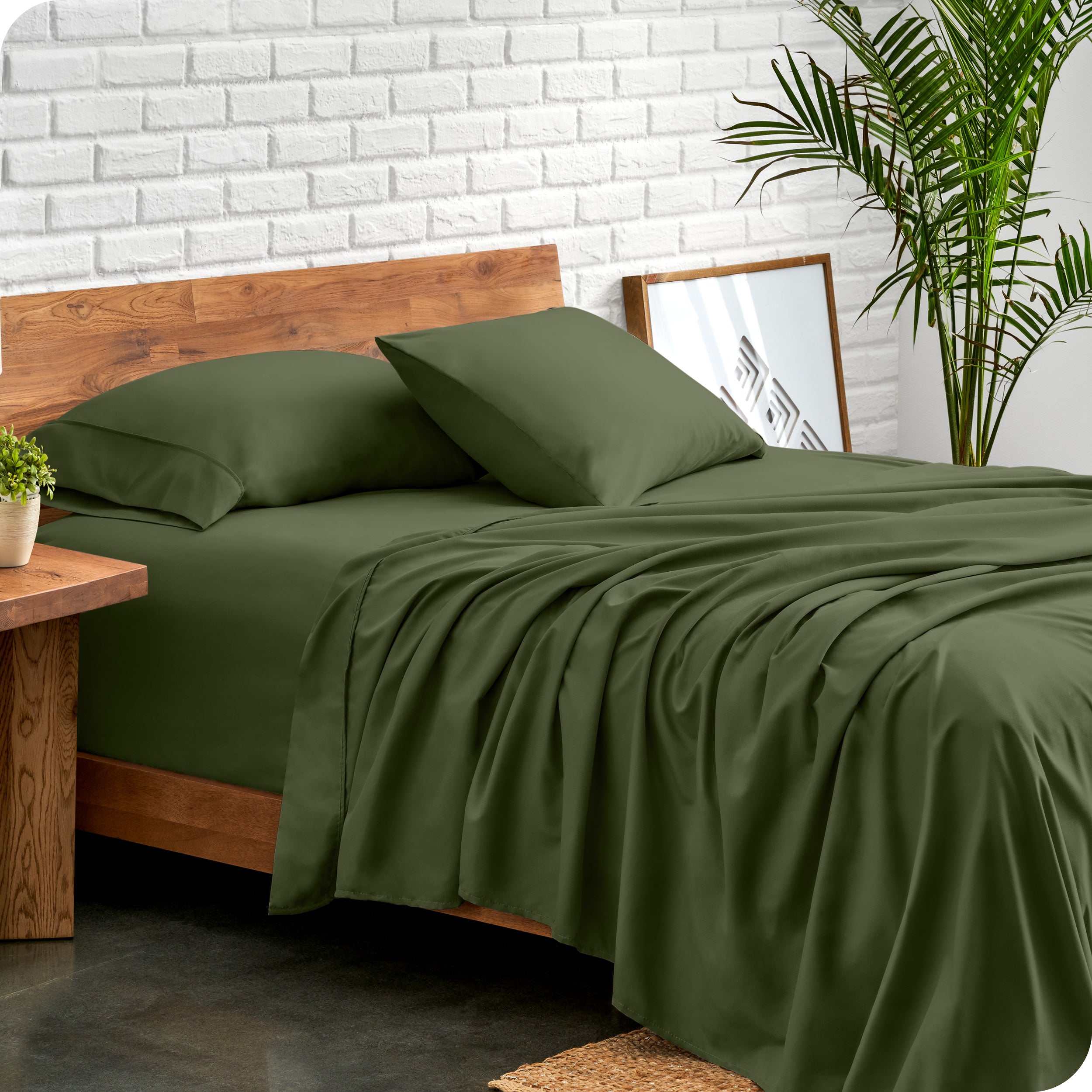 Microfiber sheets and matching pillowcases on a bed next to a large plant