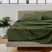 Microfiber sheets on a bed with a brick wall behind it